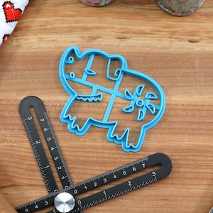 Puede incluir: Un cortador de galletas de pl&aacute;stico azul con forma de rinoceronte con un dise&ntilde;o floral en la espalda.