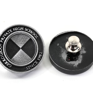 Pu&ograve; includere: Uno spillo argentato con un designo bianco e nero. Lo spillo presenta il testo "Gekkoukan Private High School Since 1982". Il retro dello spillo &egrave; nero.