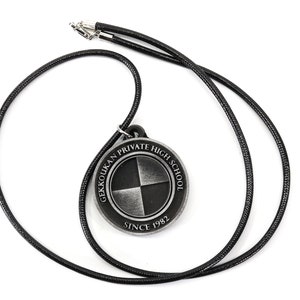 May include: A black cord necklace with a silver pendant featuring the Gekkoukan Private High School logo. The logo is a circle with a black and white quartered design and the text "Gekkoukan Private High School Since 1982".