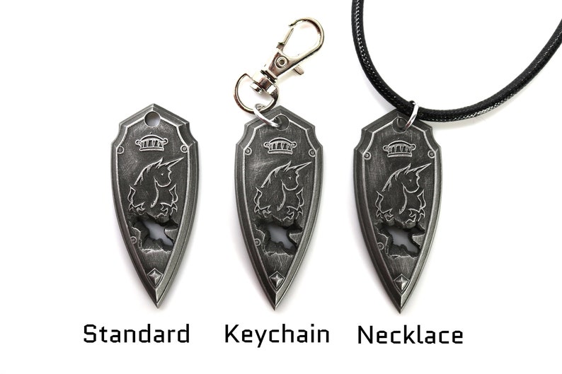 May include: A silver shield pendant with a unicorn design, shown in three variations: standard, keychain, and necklace.