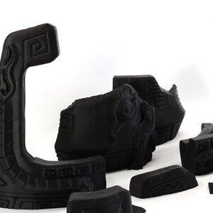 以下が含まれることがあります： 黒色の複雑な彫刻が施された3Dプリントされた部品のセット。部品は、より大きな構造を形成するために組み合わされるように設計されています。部品は、滑らかでマットな黒色のプラスチックでできています。