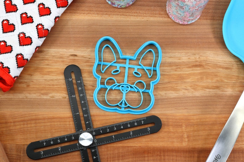 Puede incluir: Cortador de galletas de pl&aacute;stico azul con forma de cara de perro. El cortador tiene un dise&ntilde;o detallado con nariz, ojos y orejas.