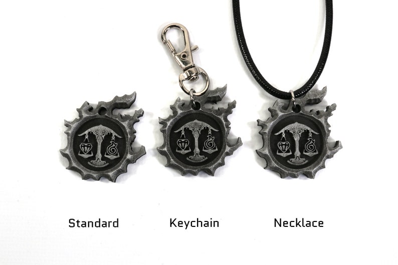 May include: Three silver-colored pendants with a black and white design of a scale with a heart and a snake on each side. The pendants are shown in three different styles: standard, keychain, and necklace.