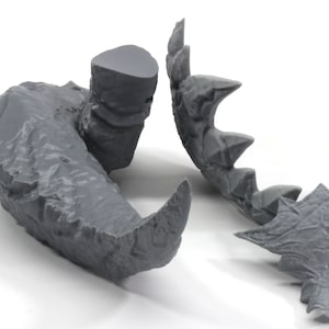 May include: A 3D printed gray model of a dragon's head, with a separate jaw piece. The head is detailed with scales and teeth.