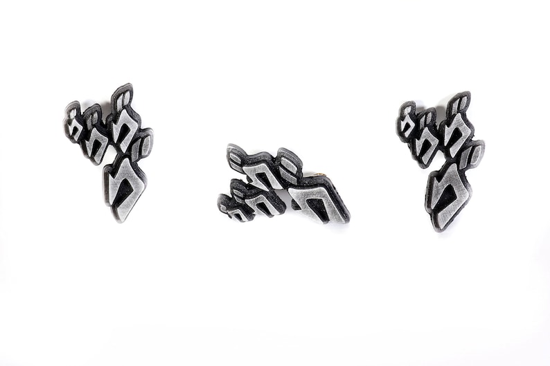May include: Three silver-colored pins with the word "JODAR" written in a stylized font.
