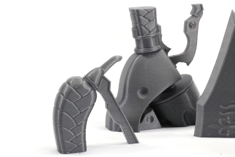 May include: A set of three gray 3D printed parts for a model gun. The parts include a handle, a trigger, and a barrel.