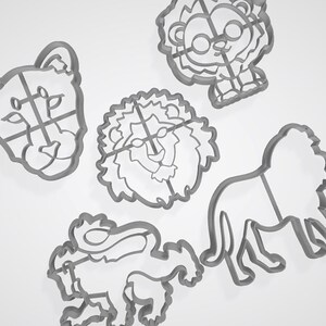 Puede incluir: Conjunto de cinco cortadores de galletas de metal con forma de leones. Los cortadores est&aacute;n en varias poses, incluyendo un le&oacute;n con melena, un le&oacute;n con corona y un le&oacute;n con una pata levantada.
