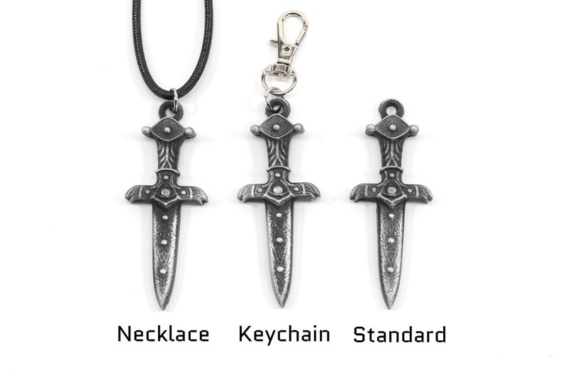 May include: Three silver dagger pendants in different styles: necklace, keychain, and standard. Each pendant features a detailed design with a pointed tip and a cross-shaped handle.