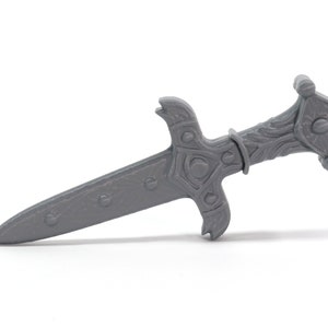 May include: A gray plastic dagger with a detailed handle and a pointed blade.