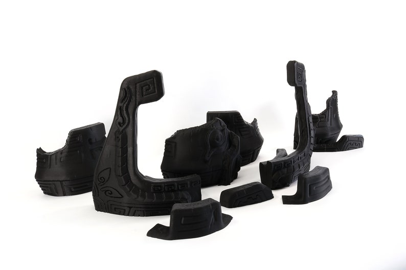 以下が含まれることがあります： 黒く複雑に彫刻された3Dプリントパズルピースのセット。ピースはボートの形をしており、さまざまな幾何学模様が施されています。