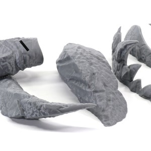 May include: Five gray 3D printed pieces of a dragon sculpture. The pieces include the head, tail, and two wings.