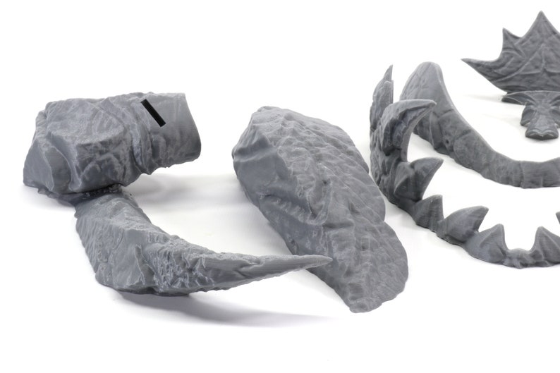 May include: Five gray 3D printed pieces of a dragon sculpture. The pieces include the head, tail, and two wings.
