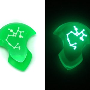 May include: A green glow-in-the-dark resin pendant with a white Sagittarius constellation design.