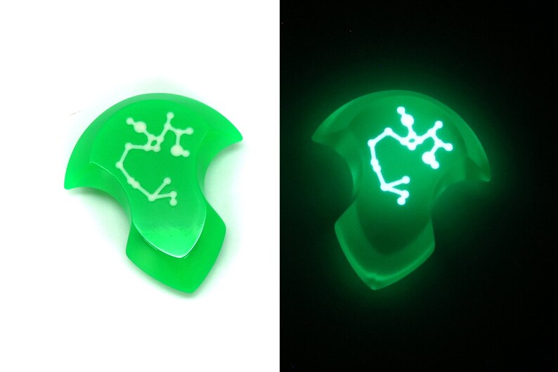May include: A green glow-in-the-dark resin pendant with a white Sagittarius constellation design.