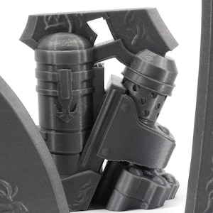 May include: A 3D printed model of a knight in armor, with a helmet and a sword. The knight is standing on a base with a decorative design.