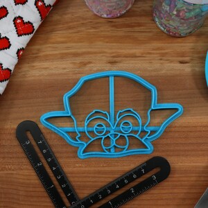 Pu&ograve; includere: Tagliapasta in plastica blu a forma di personaggio dei cartoni animati con occhi e orecchie grandi.
