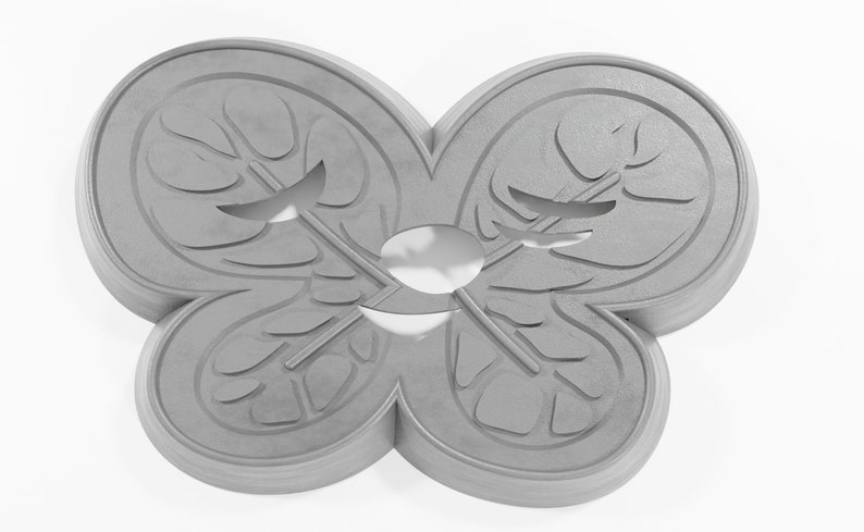 May include: A gray, ceramic butterfly-shaped cookie cutter with a detailed design. The cutter has a symmetrical design with two wings on each side.