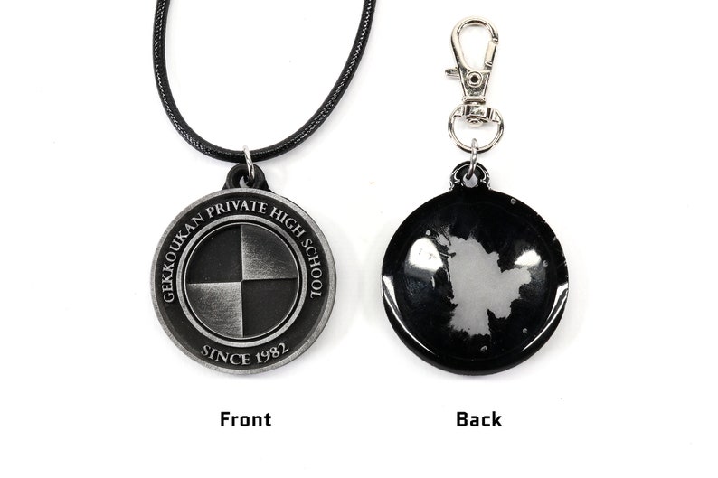 May include: A black and silver necklace with a round pendant featuring the text "Gekkoukan Private High School Since 1982". The pendant has a black and white checkered design. The back of the pendant is black and has a silver design.