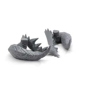May include: Gray plastic model of a dinosaur tail with spikes and textured skin. The tail is broken into several pieces.