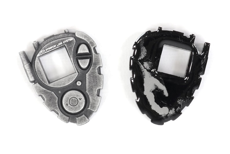 May include: A silver and black Digimon toy with a screen and buttons. The toy is in two states, one with a clean surface and the other with a worn surface.