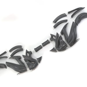 May include: A 3D printed model of a bow and arrow, disassembled into multiple pieces. The bow is made of a dark gray plastic and has a complex, intricate design. The arrow is also made of dark gray plastic and has a simple, straight design.