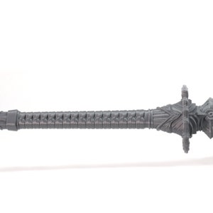 May include: A grey plastic sword with a detailed design. The sword has a sharp point and a decorative handle.