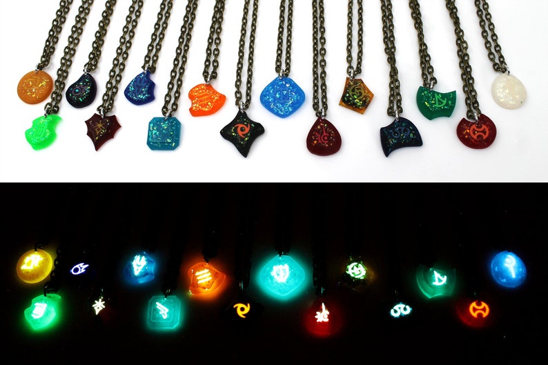 May include: A set of 15 necklaces with glow-in-the-dark pendants featuring various symbols and designs. The pendants are made of clear resin with embedded glitter and glow-in-the-dark powder. The necklaces are displayed on a white surface in the top image and in a dark room in the bottom image.