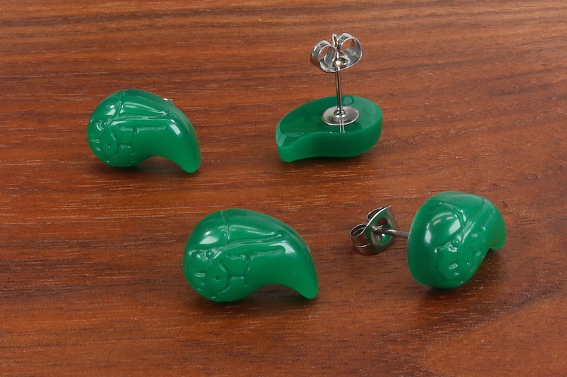 May include: A pair of green jade earrings in the shape of a teardrop with a silver post and butterfly back.