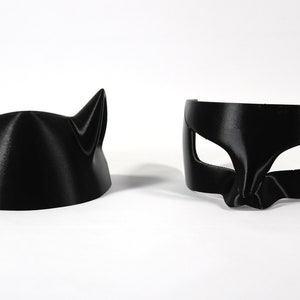 May include: Two black cat masks, one with ears and one with eye holes.