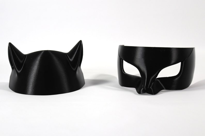 May include: Two black cat masks, one with ears and one with eye holes.