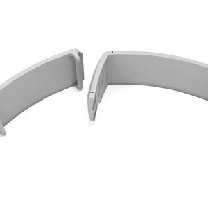 May include: Two light gray, curved, architectural components are displayed against a white background. Each piece has a rounded top and a rectangular base. The pieces are separated, suggesting they may fit together.