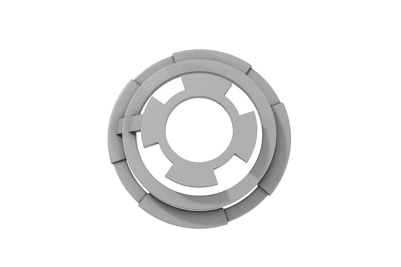 May include: A silver metal washer with a circular shape and a central hole. The washer has a series of concentric rings and a starburst pattern.