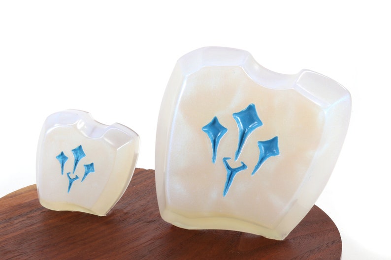Pu&ograve; includere: Due scudi in ceramica bianca con un designo blu. Lo scudo pi&ugrave; grande &egrave; leggermente pi&ugrave; alto del pi&ugrave; piccolo. Entrambi gli scudi hanno un design stilizzato blu a tre punte.