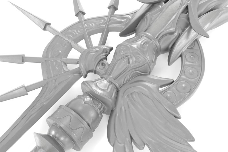 May include: A silver-colored metal sculpture with intricate details, featuring a central figure with wings and a circular base with spikes.