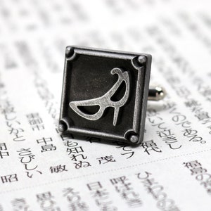 May include: Silver cufflinks with a square design featuring a stylized high heel shoe.