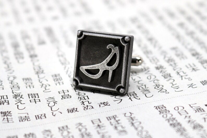 May include: Silver cufflinks with a square design featuring a stylized high heel shoe.
