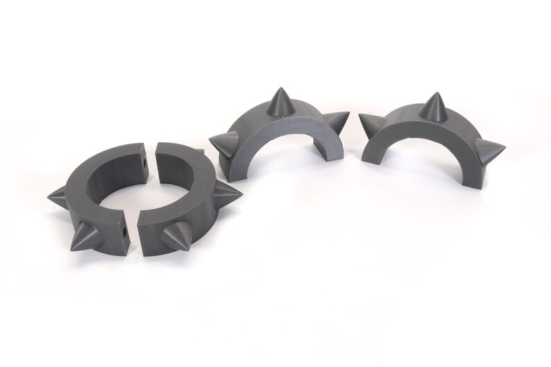 May include: Three grey plastic spiked rings, two are half circles and one is a full circle.