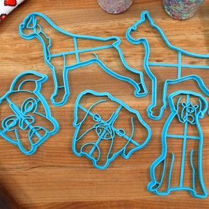 Puede incluir: Cuatro cortadores de galletas de plástico azul con forma de perros boxer. Dos cortadores son del cuerpo completo del perro, y dos son de la cabeza del perro.