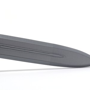 May include: A close-up of the blade of a gray sword. The blade has a textured surface and a sharp point.