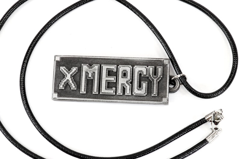 May include: A silver necklace with a rectangular pendant that says "X MERCY" in a pixelated font.