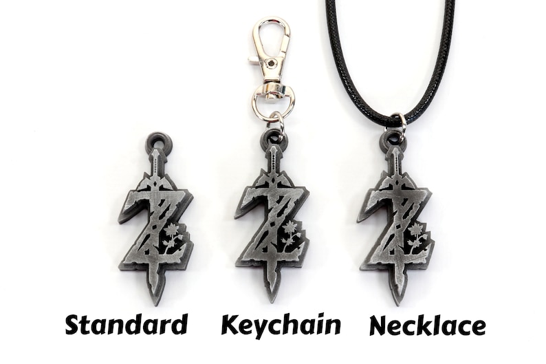 May include: Three versions of a silver-colored pendant featuring a stylized sword and the letter Z. The pendant is available as a standard charm, a keychain, and a necklace.