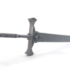 May include: A gray metal sword with a decorative handle and a detailed design on the blade.