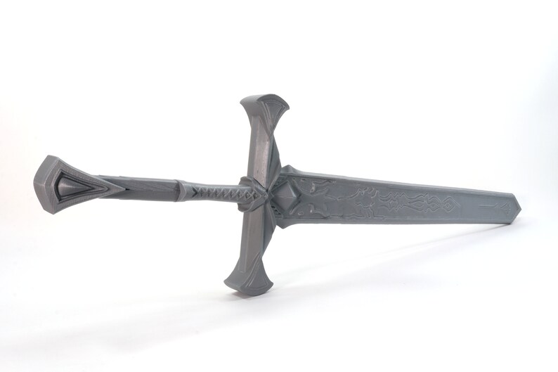 May include: A gray metal sword with a decorative handle and a detailed design on the blade.