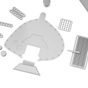 Puede incluir: Un conjunto de piezas de modelo de pl&aacute;stico gris para un kit de maquetas. Las piezas incluyen una pieza grande, curva, con un recorte, una pieza rectangular m&aacute;s peque&ntilde;a con un dise&ntilde;o en relieve y varias piezas rectangulares m&aacute;s peque&ntilde;as con agujeros.