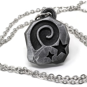 May include: A silver chain necklace with a pendant featuring a stylized spiral design and two stars. The pendant is made of a textured metal and has a slightly aged look.