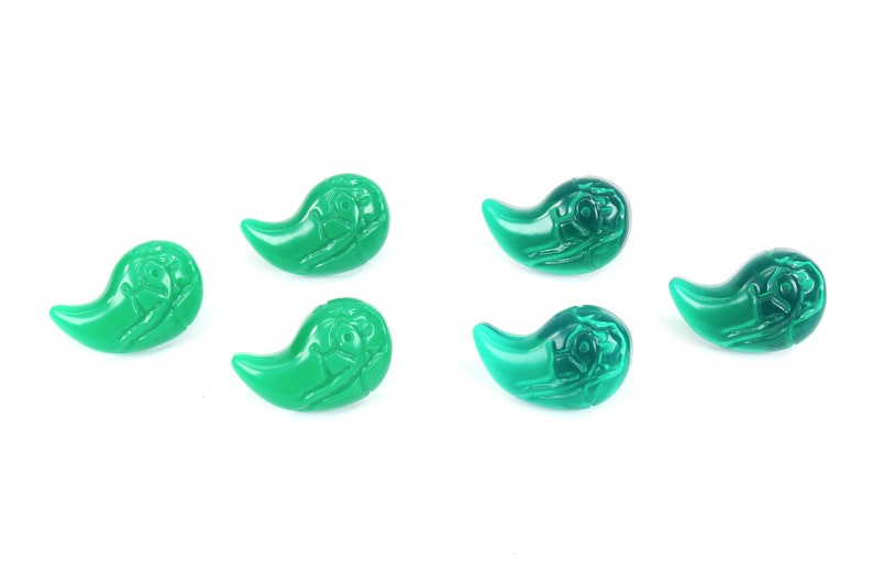 K&ouml;nnte beinhalten: F&uuml;nf t&uuml;rkisfarbene Glasperlen in Tropfenform mit einem erhabenen Design. Die Perlen sind alle gleich gro&szlig; und gleich geformt.