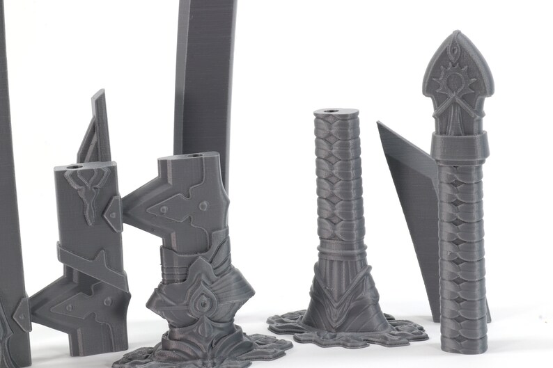 May include: A set of five grey 3D printed swords with intricate details. The swords have different shapes and sizes, and some have a braided design.