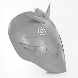 May include: A gray, 3D printed mask with a geometric design. The mask has a pointed top and a wide, open mouth. The eyes are covered with a mesh material.