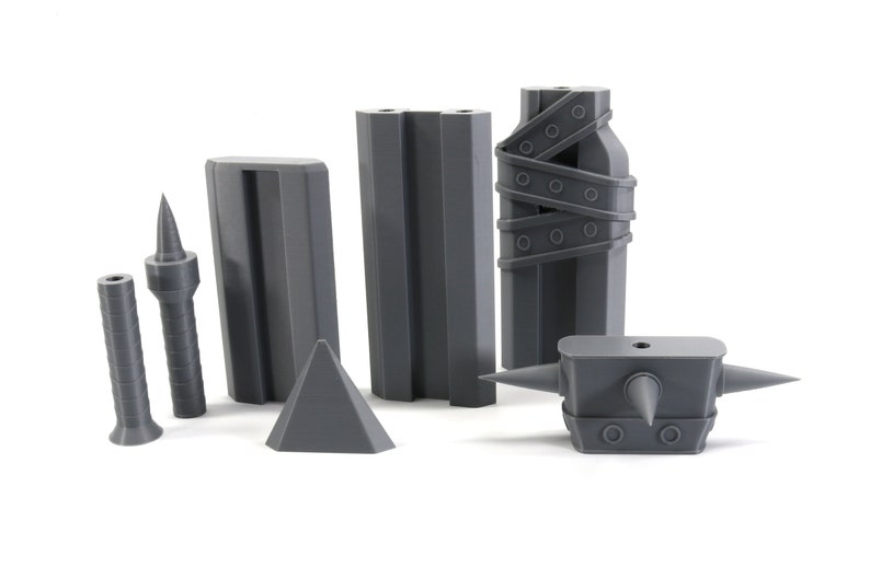 May include: A set of grey 3D printed dungeon accessories for tabletop role-playing games. The set includes a spiked wall, a spiked trap, a spiked club, and a spiked pillar.
