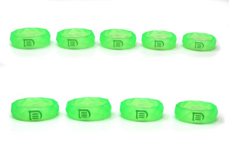 May include: Ten green silicone rings with a raised letter "D" on each ring.